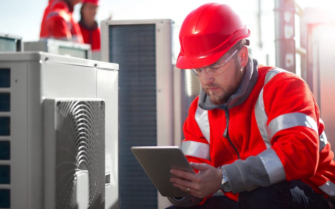 Commercial HVAC technician from ABC in Ottawa inspects a rooftop hvac unit