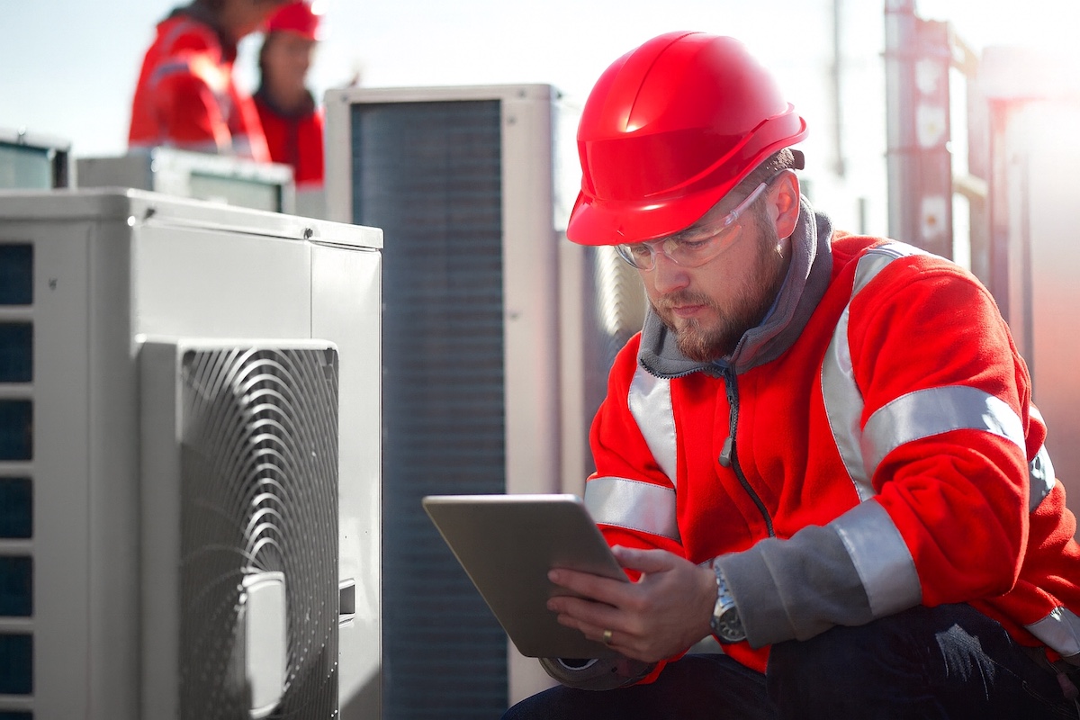 Commercial HVAC technician from ABC in Ottawa inspects a rooftop hvac unit